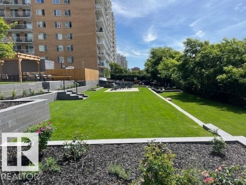 Manicured lawn area with tiered landscaping, concrete block retaining walls, and planted garden beds - 1101 10011 123 Street, Edmonton, AB 