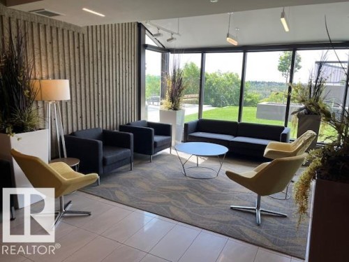 Spacious lounge area featuring a full wall of floor-to-ceiling windows, offering panoramic outdoor scenery - 1101 10011 123 Street, Edmonton, AB 