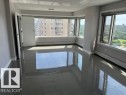 Expansive room featuring multiple large windows, dark grey tile flooring, white baseboards, and light grey walls - 1101 10011 123 Street, Edmonton, AB 