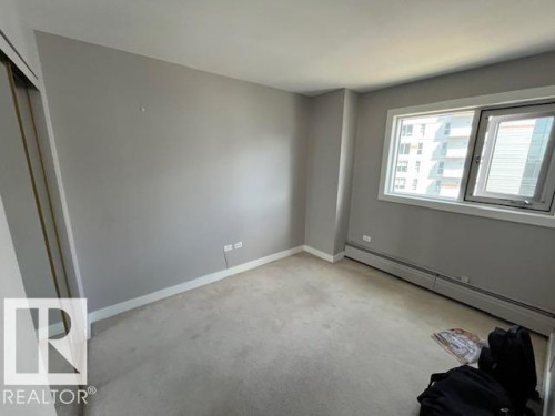 Carpeted room with a large window and baseboard heating - 1101 10011 123 Street, Edmonton, AB 