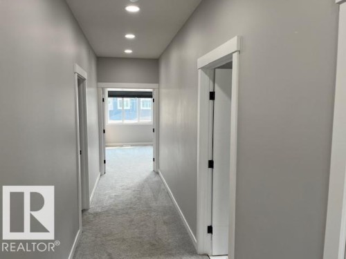 Hallway featuring recessed ceiling lighting, light gray wall paint, and light gray carpeting - 3810 46 Avenue, Beaumont, AB 