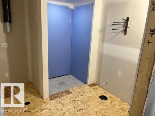 Framed space with OSB subflooring, partially installed drywall, and blue moisture-resistant wallboard - 3810 46 Avenue, Beaumont, AB 