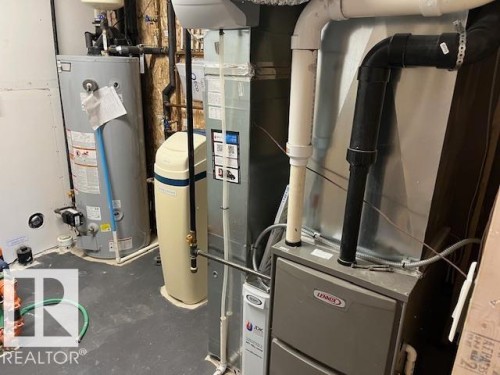 Utility area featuring a water heater, water softener, and HVAC system - 3810 46 Avenue, Beaumont, AB 