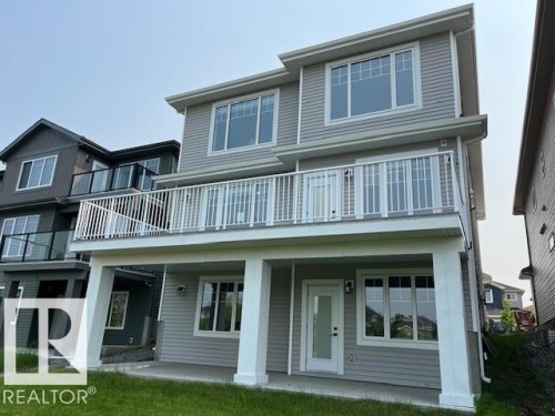 Rear exterior featuring light gray siding - 3810 46 Avenue, Beaumont, AB 