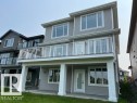 Rear exterior featuring light gray siding - 3810 46 Avenue, Beaumont, AB 