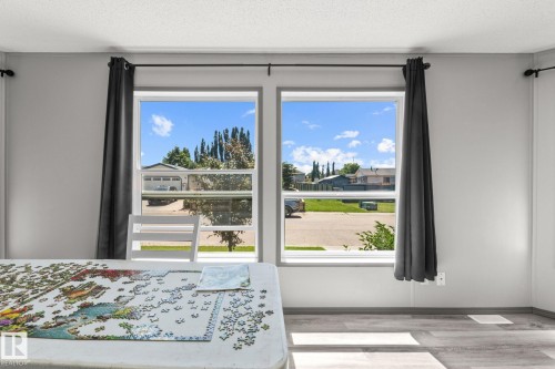 Dual windows with black curtain rods, grey curtains, and white trim - 31 Graywood Cove, Stony Plain, AB 