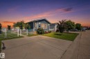 Single-story residence featuring blue horizontal siding and a concrete driveway - 31 Graywood Cove, Stony Plain, AB 