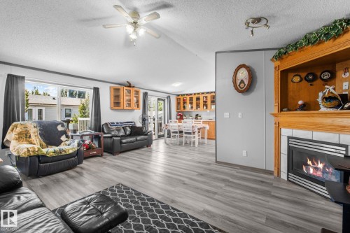 Open-concept living area featuring wood-finish flooring, a vaulted ceiling, and a ceiling fan - 31 Graywood Cove, Stony Plain, AB 