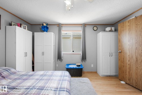 Bright room featuring light wood-finish flooring and a window with blinds - 31 Graywood Cove, Stony Plain, AB 