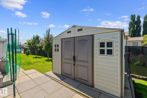 Detached outdoor storage shed featuring double doors and side windows - 31 Graywood Cove, Stony Plain, AB 