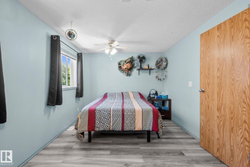 Room featuring light blue walls, wood-finish flooring, a window with exterior views, and a ceiling fan - 31 Graywood Cove, Stony Plain, AB 