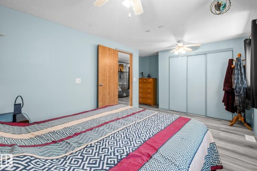 Bedroom featuring light blue walls, wood-finish flooring, and a ceiling fan - 31 Graywood Cove, Stony Plain, AB 