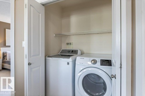 Dedicated laundry closet featuring a white top-load washing machine, white front-load dryer, and an upper wire shelf - 1119 Potter Greens, Edmonton, AB - Indoor Photo Showing Laundry Room