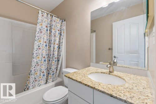 Bathroom featuring a combination shower and tub, a vanity with a light-colored countertop, and a wall-mounted mirror - 1119 Potter Greens, Edmonton, AB - Indoor Photo Showing Bathroom