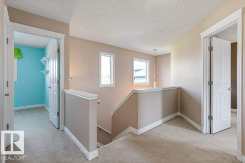 Upper-level landing featuring neutral carpeting and light beige wall paint - 1119 Potter Greens, Edmonton, AB - Indoor Photo Showing Other Room