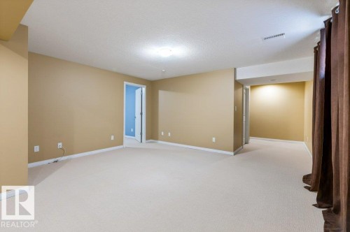 Expansive room featuring light-toned carpeting, neutral wall paint, and white baseboards - 1119 Potter Greens, Edmonton, AB - Indoor Photo Showing Other Room