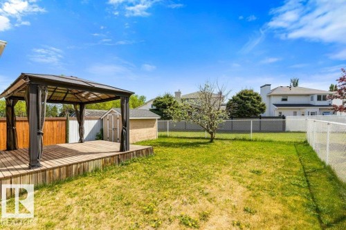Backyard featuring a wooden deck with a gazebo, expansive lawn, and two storage sheds - 1119 Potter Greens, Edmonton, AB - Outdoor