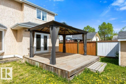 Spacious rear deck with a black gazebo, offering direct access through double glass doors - 1119 Potter Greens, Edmonton, AB - Outdoor With Exterior