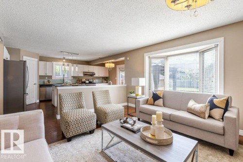 Spacious living area featuring a bay window with blinds, wood-finish flooring, and recessed lighting - 1119 Potter Greens, Edmonton, AB - Indoor Photo Showing Living Room