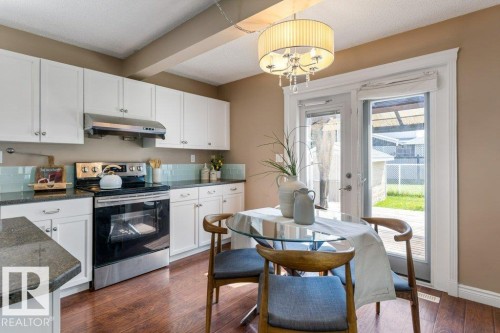 Kitchen featuring white cabinetry, a stainless steel range with overhead ventilation, and a light blue subway tile backsplash - 1119 Potter Greens, Edmonton, AB - Indoor