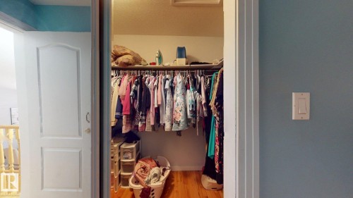 Walk-in closet with built-in shelving, hanging rod, and wood-finish flooring - 3738 28A Street, Edmonton, AB 