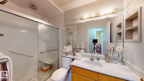 Bathroom featuring a walk-in shower with subway tile surround, frameless glass enclosure, and dual showerheads - 3738 28A Street, Edmonton, AB 