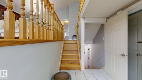 Entryway featuring light wood-finish stairs and an ornate wood-finish balustrade - 3738 28A Street, Edmonton, AB 