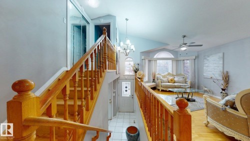 Bright living space with vaulted ceilings featuring a bay window, wood-finish flooring, and a ceiling fan - 3738 28A Street, Edmonton, AB 