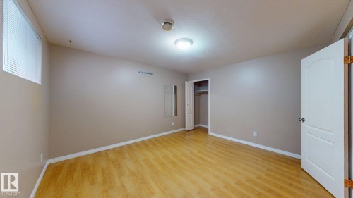 Room featuring wood-finish flooring, neutral wall tones, and white trim - 3738 28A Street, Edmonton, AB 