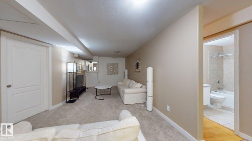 Carpeted living area featuring recessed lighting, a built-in media console, and a neutral wall color - 3738 28A Street, Edmonton, AB 