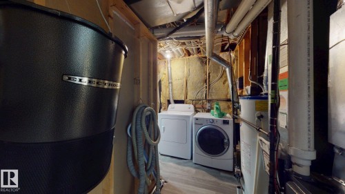 Utility area featuring a water heater, central vacuum system, washer, and dryer - 3738 28A Street, Edmonton, AB 