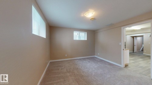 Spacious room featuring neutral wall paint, light-colored carpet flooring, and white trim - 3738 28A Street, Edmonton, AB 