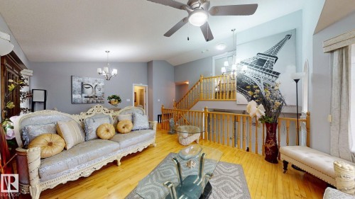Spacious living area featuring polished wood flooring, a ceiling fan with integrated lighting, and neutral wall tones - 3738 28A Street, Edmonton, AB 
