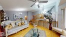 Spacious living area featuring polished wood flooring, a ceiling fan with integrated lighting, and neutral wall tones - 3738 28A Street, Edmonton, AB 