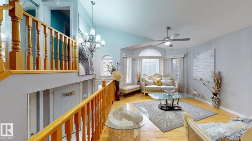 Open-concept living space featuring wood-finish flooring, a vaulted ceiling, and a bay window - 3738 28A Street, Edmonton, AB 