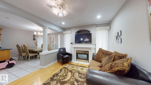 Living area featuring a built-in fireplace with a mantel, recessed lighting, and wood-finish flooring - 3738 28A Street, Edmonton, AB 