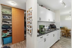 Kitchen with white cabinetry, dark countertops, and white subway tile backsplash - 