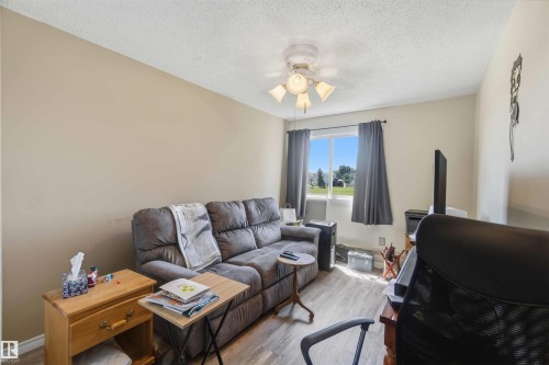 Neutral wall paint, light wood-finish flooring, and a ceiling fan with integrated lighting - 204 4601 131 Avenue, Edmonton, AB 