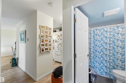 Bathroom featuring a blue ceiling, white trim, and a patterned shower curtain - 