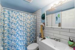 Bathroom featuring white subway tile walls, a single vanity with an integrated sink, and a mirrored medicine cabinet with overhead lighting - 