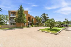 Multi-story brick exterior with balconies and a paved parking area - 