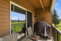 Private balcony featuring wood-finish siding and a black metal railing - 