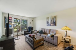 Living area featuring wood-finish flooring, a full-wall sliding glass door, and a private balcony with metal railings - 