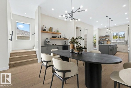Open-concept dining area featuring light wood-finish flooring and a contemporary chandelier - 10932 132 Street, Edmonton, AB - Indoor Photo Showing Dining Room