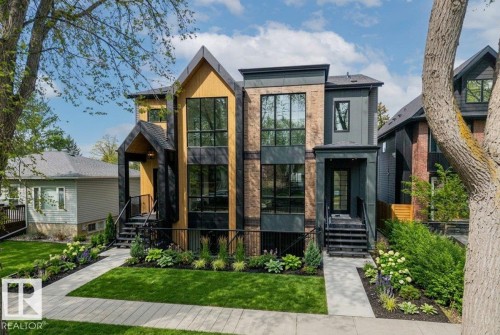 Modern facade featuring expansive window banks, mixed material siding, and a gabled entry - 10932 132 Street, Edmonton, AB - Outdoor With Facade