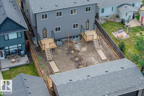 Rear exterior featuring two newly constructed wooden decks with black metal and glass railings - 10932 132 Street, Edmonton, AB - Outdoor With Deck Patio Veranda