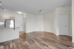 Open-concept living area featuring wood-finish flooring - 
