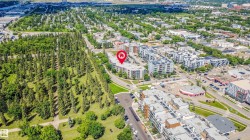 Aerial perspective highlighting a multi-story building within a developed area - 