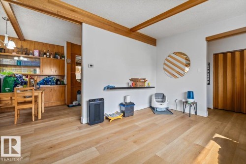 Bright interior space featuring light wood-finish flooring, white walls, and exposed wood beams - 8736 72 Street Nw, Edmonton, AB - Indoor Photo Showing Other Room
