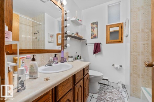 Bathroom featuring a vanity with wood-finish cabinetry, a single basin sink, and a light-colored countertop - 8736 72 Street Nw, Edmonton, AB - Indoor Photo Showing Bathroom